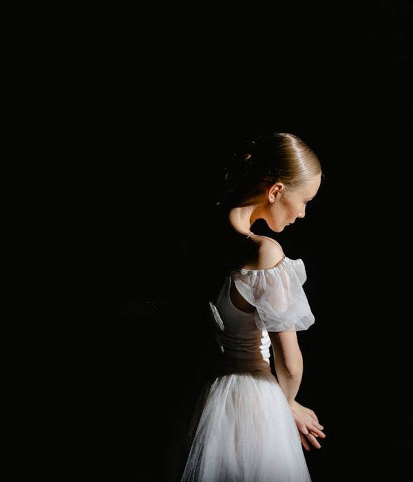 Жінка виконує плавний кардіо-рух у темній студії з лаймовим світлом.